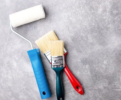 Các dụng cụ sơn nhà gồm con lăn sơn cán xanh và chổi quét sơn chuẩn bị cho việc thi công chống thấm tường vào mùa mưa